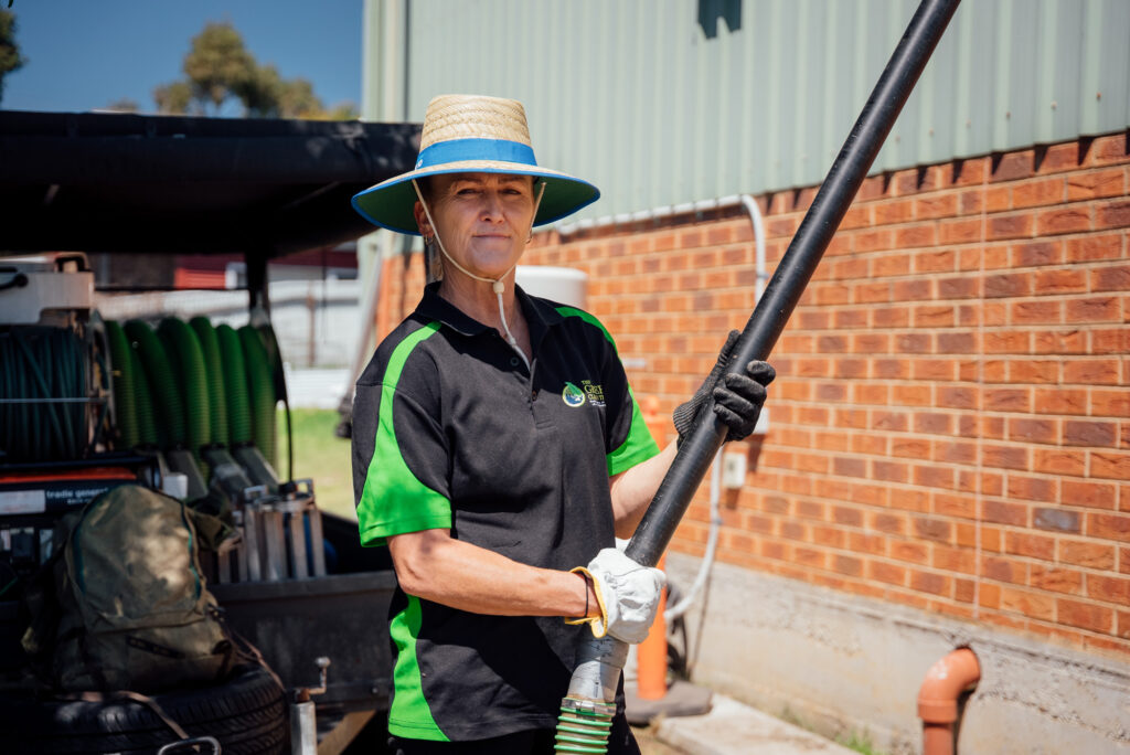 A Green Clean Team staff member cleaning gutters with a suction hose from the ground during an eco-friendly gutter cleaning job in Bendigo, Central Victoria.