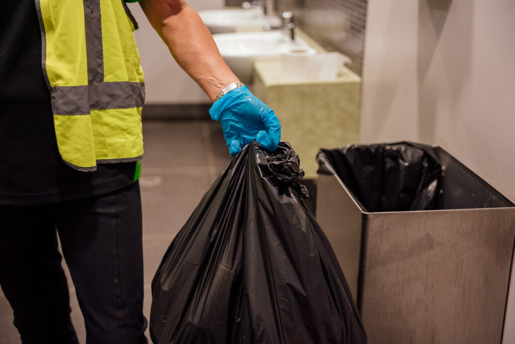 Green Clean Team staff member safely removing a bag of contaminated rubbish during a biohazard clean in Bendigo, Central Victoria.