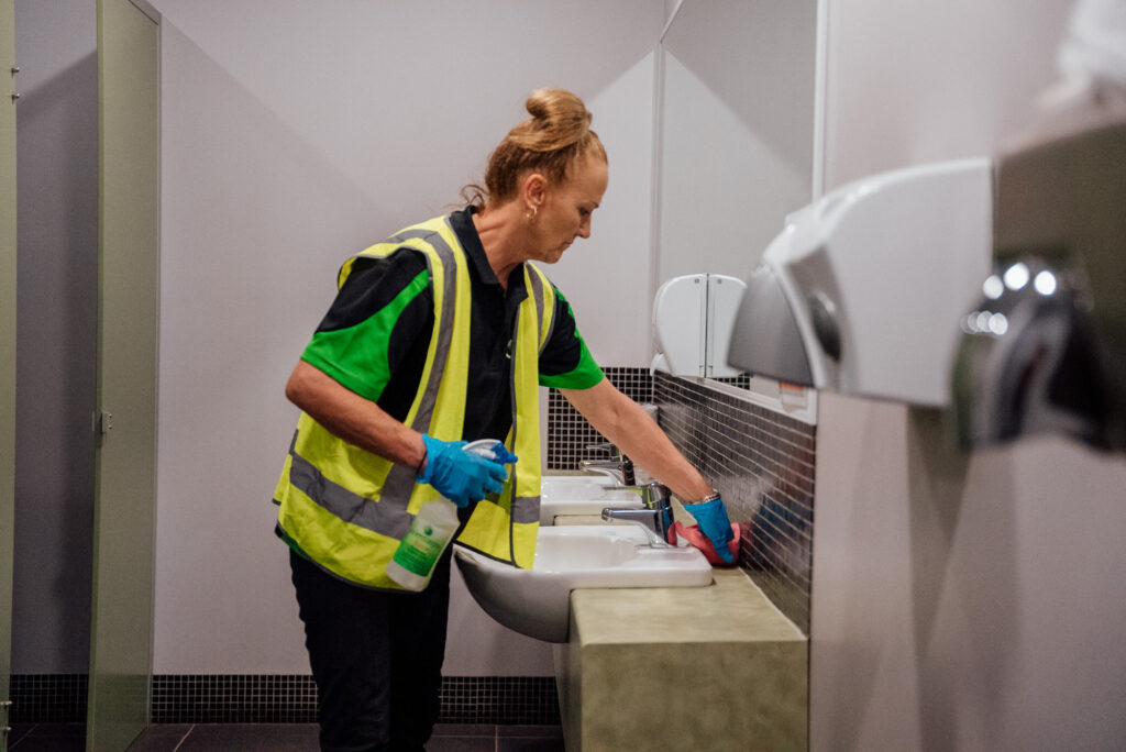 A Green Clean Team member wiping down a bathroom as part of eco-friendly commercial cleaning job in Bendigo, Central Victoria