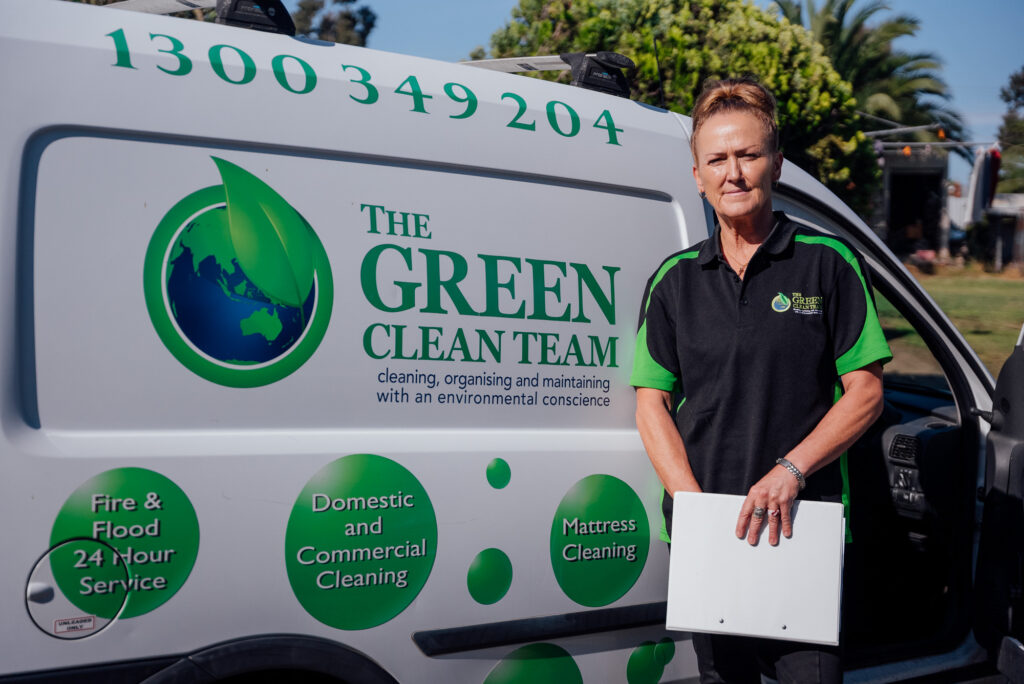 Green Clean Team staff member standing in front of a compay car getting ready to go into a home organising job.